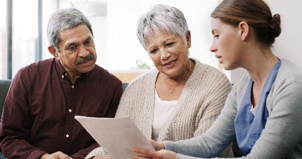 Actor portrayal of healthcare worker showing results to an older woman and older man