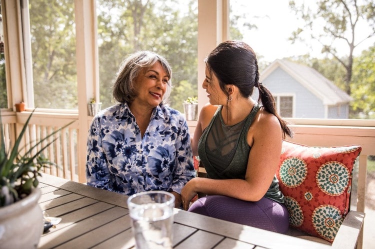 Woman talking to an older woman at a table