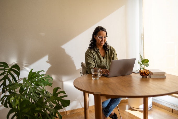 Woman surfing her laptop smiling