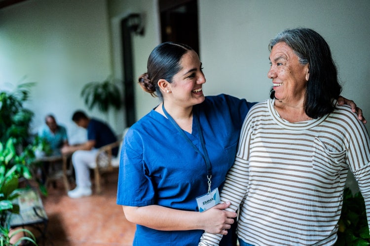 Actor portrayal of a nurse assisting an older adult woman